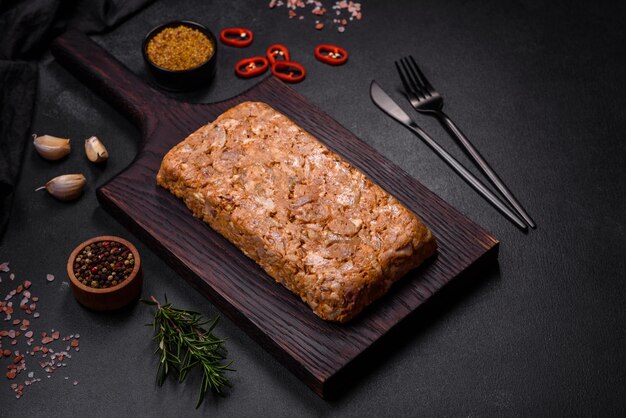 Carne sabrosa o rollo en una tabla de cortar de madera con especias y hierbas