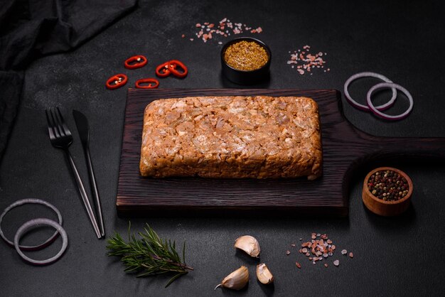 Carne sabrosa o rollo en una tabla de cortar de madera con especias y hierbas