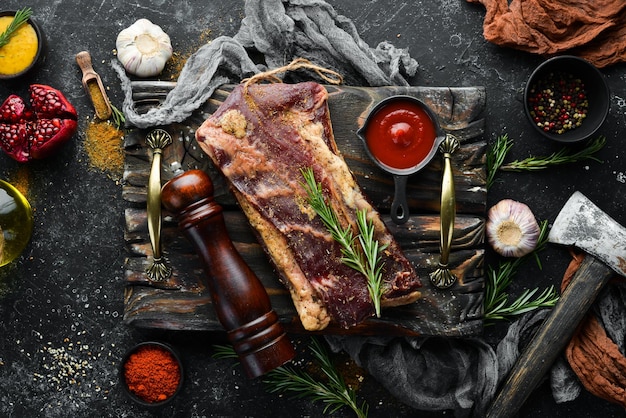 Carne salada seca con romero y especias Jamon Sobre un fondo de piedra negra Vista superior