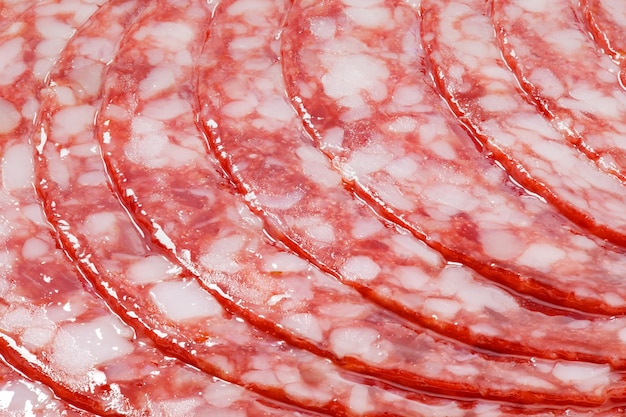 Foto carne de salchicha de salami con tocino cortada en círculos primer plano