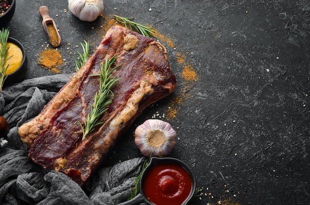 Carne salgada seca com alecrim e especiarias Jamon Em um fundo de pedra preta Vista superior