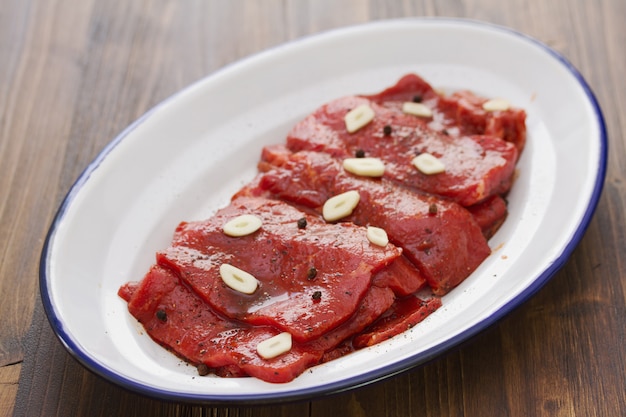 Carne con salsa y ajo en plato blanco