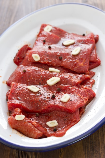 Carne con salsa y ajo en plato blanco