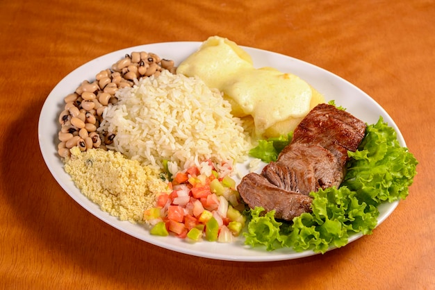 Carne seca al sol con frijoles arroz farofa yuca y vinagreta Carne de sol Nordeste brasileño