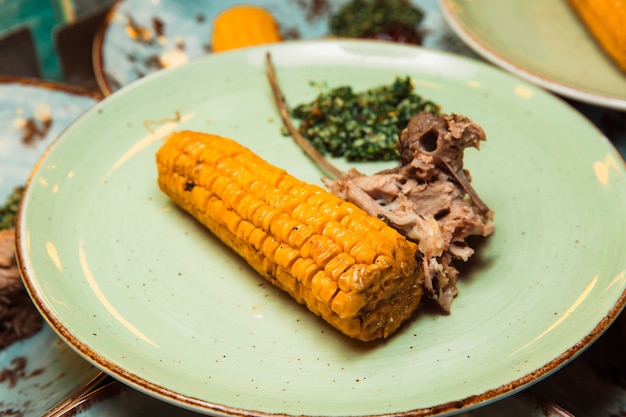 Carne suculenta preparada na hora é servida na espiga de milho e molho verde