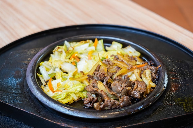 Carne teriyaki yakiniku servido com legumes em um prato quente