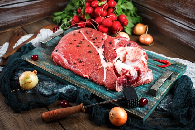 Carne de ternera fresca sobre mesa de madera rústica