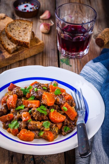 Carne de ternera guisada con verduras sobre fondo de madera