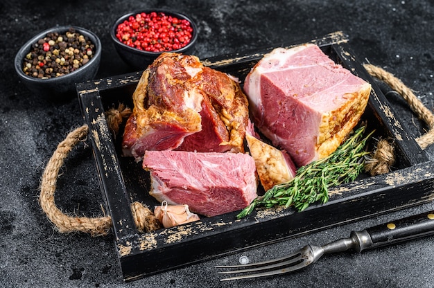 Carne de tocino de losa de cerdo ahumado en rodajas en una bandeja de madera.