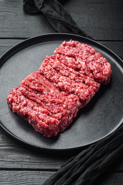 Carne de vacuno de mármol picada, sobre fondo de mesa de madera negra