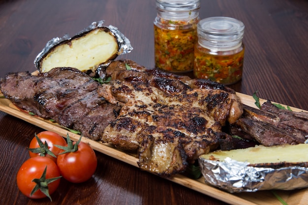 Carne con verduras en un plato de madera