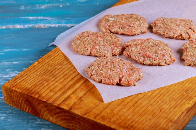 Foto carnes crudas de carne de res molida chuletas de filete de hamburguesa con condimento en tablas de madera vintage