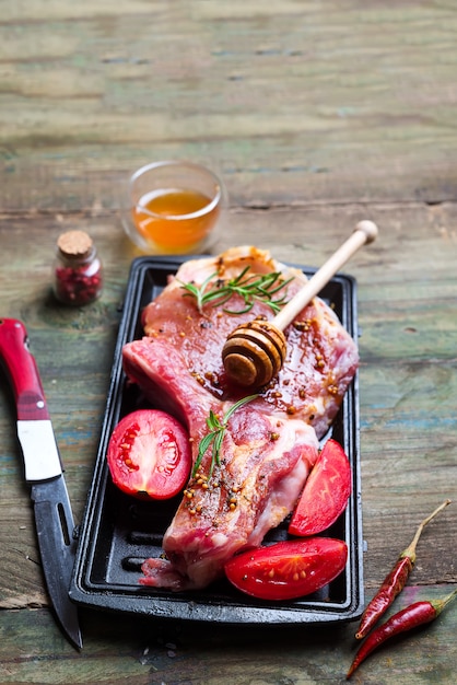 Foto carnes crudas y sartenes con condimentos, aderezos e ingredientes