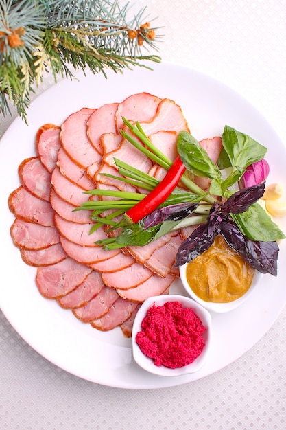 Carnes frías en una mesa festiva en un plato blanco