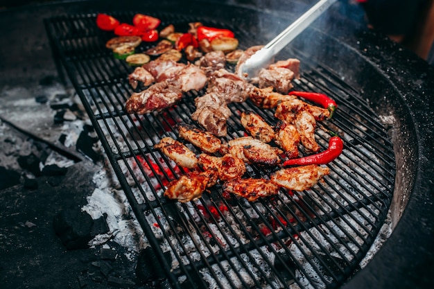 Carnes grelhadas na churrasqueira com fogo e carvão