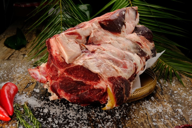 Foto carnicería carne cruda fresca cordero costilla grande y filete listo para cocinar con materia verde en placa de madera aislada