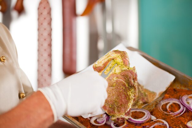 Carnicero con carne cocida con tenedor del chef