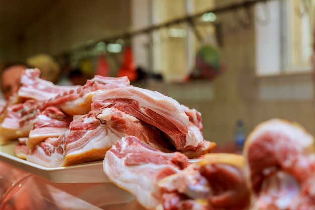 Carnicero corta un trozo de carne en el mercado.