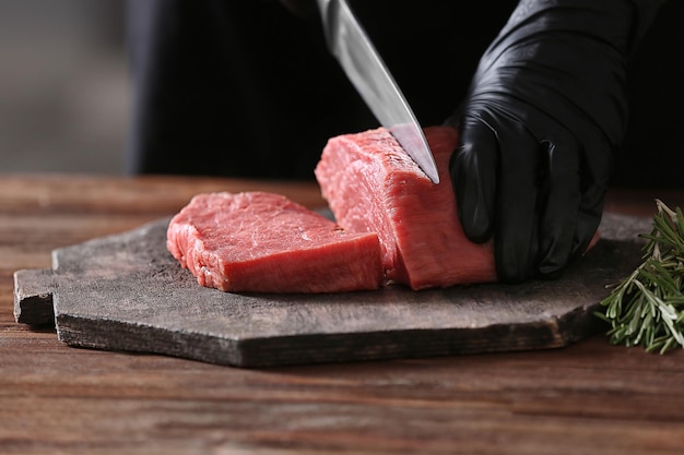 Carnicero cortando carne de cerdo en la cocina