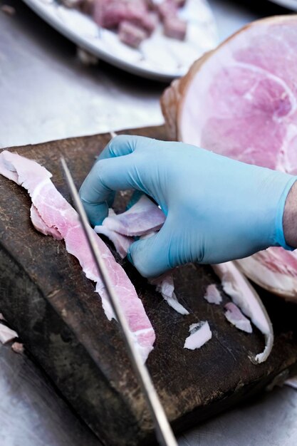 Foto carnicero cortando jamón en una carnicería