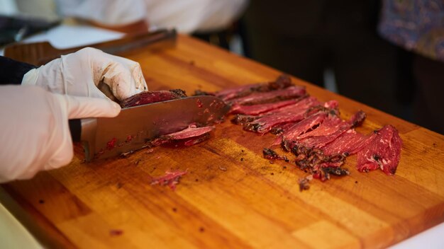 Carnicero cortando rebanadas de carne fresca