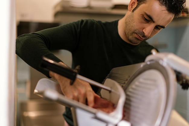 Carnicero lonchas de jamón con cortadora eléctrica