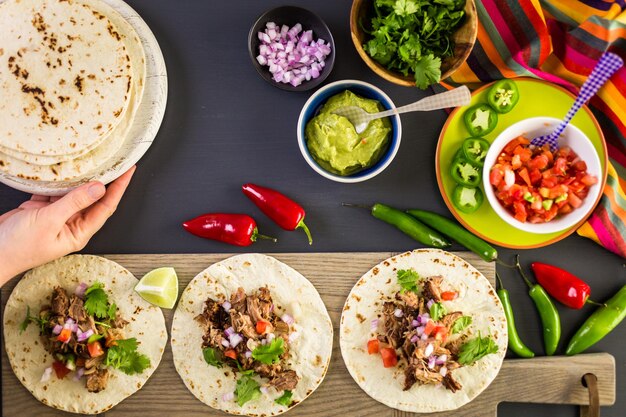 Carnitas de cerdo desmenuzadas con pico de gallo sobre tortilla de harina.