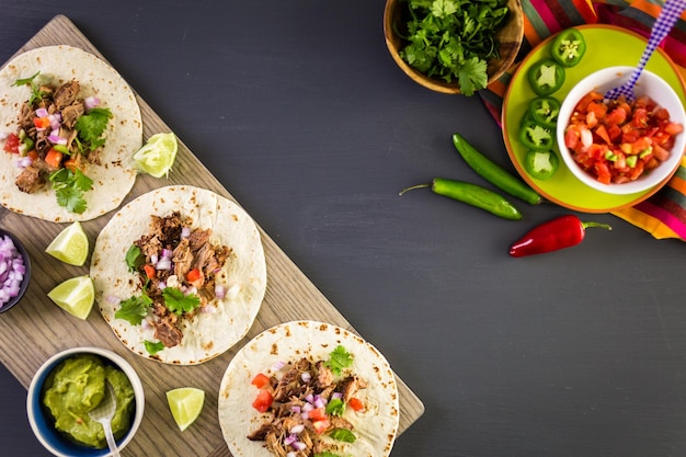 Carnitas de cerdo desmenuzadas con pico de gallo sobre tortilla de harina.