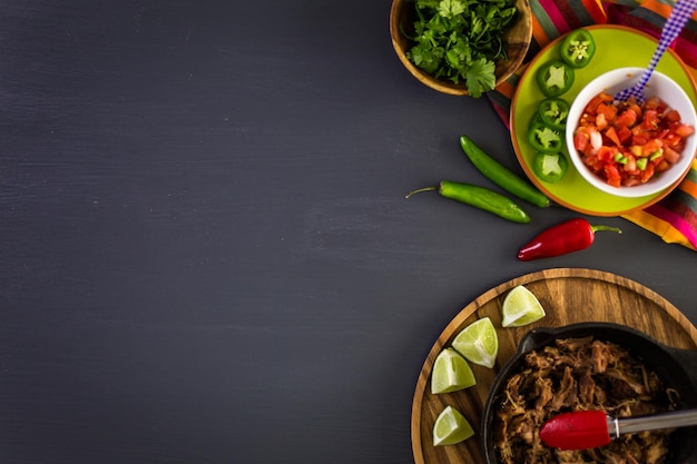 Carnitas de cerdo desmenuzadas con pico de gallo sobre tortilla de harina.