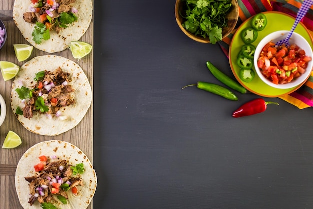 Carnitas de cerdo desmenuzadas con pico de gallo sobre tortilla de harina.