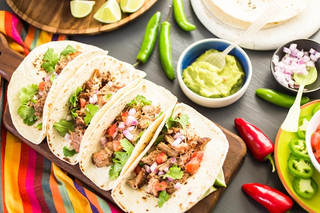 Carnitas de cerdo desmenuzadas con pico de gallo sobre tortilla de harina.