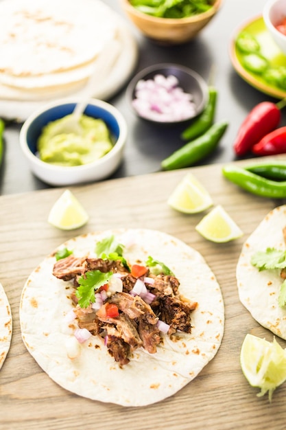 Carnitas de porco desfiado com pico de gallo numa tortilha de farinha.