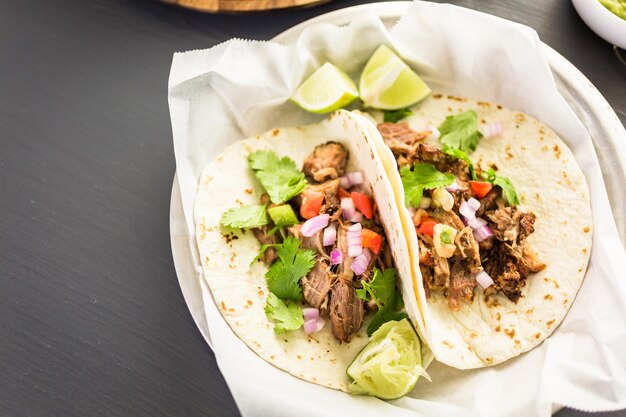 Carnitas de porco desfiado com pico de gallo numa tortilha de farinha.