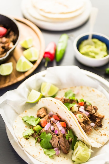 Carnitas de porco desfiado com pico de gallo numa tortilha de farinha.