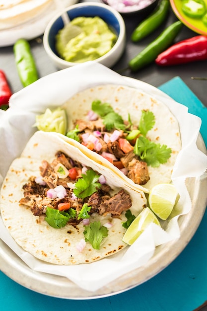 Carnitas de porco desfiado com pico de gallo numa tortilha de farinha.