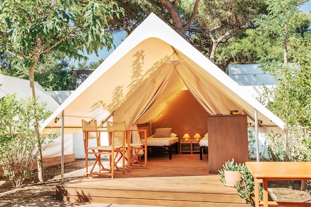 Carpa abierta glamping con interior acogedor en un día soleado carpa de camping de lujo para vacaciones de verano al aire libre