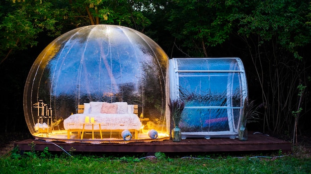 Carpa burbuja transparente en glamping por la noche