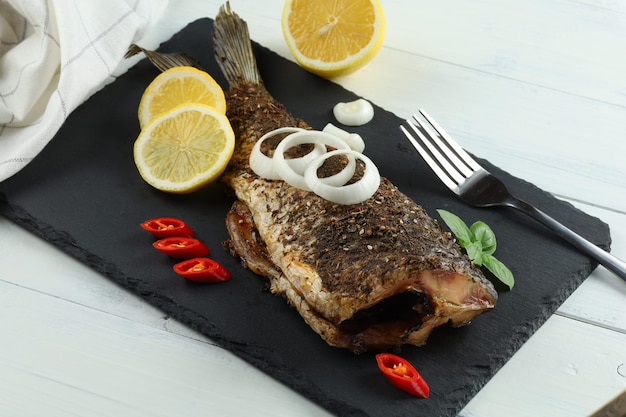 Carpa frita con verduras tomate y limón Delicioso pescado frito