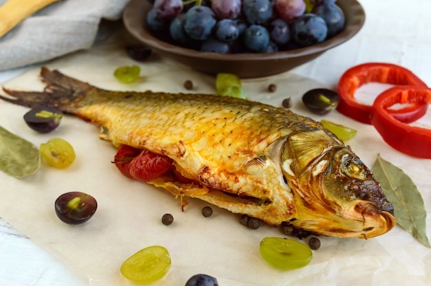 Carpa de pescado al horno, pimientos rellenos y uvas