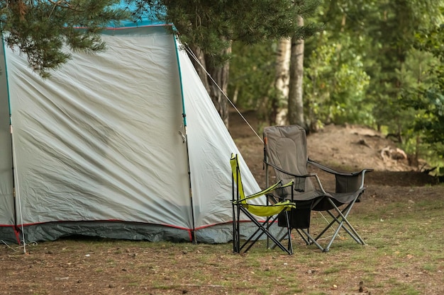 Carpa con sillas turísticas en el bosque