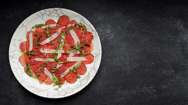 Carpaccio de carne con queso y rúcula