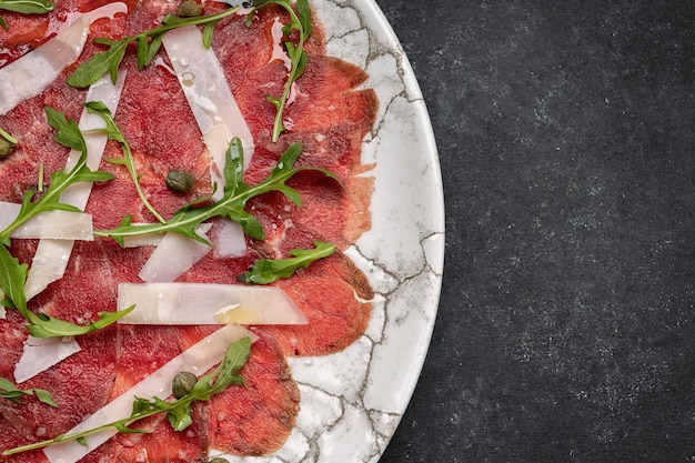 Carpaccio de carne con queso y rúcula