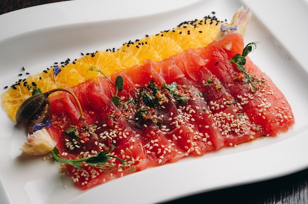 Carpaccio de atum com laranja em prato branco