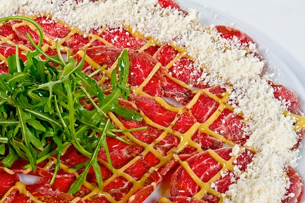 Carpaccio de carne bovina com queijo parmesão e rúcula