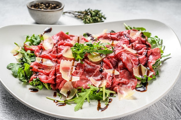 Carpaccio de carne italiana com salada de rúcula e queijo parmesão