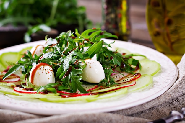 Carpaccio de rábano con rúcula, mozzarella y salsa balsámica. Comida sana. Ensalada Daikon.