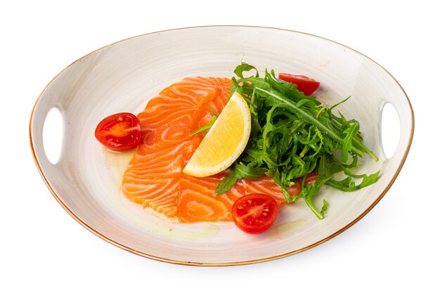 Carpaccio de salmón con rúcula aislado en blanco