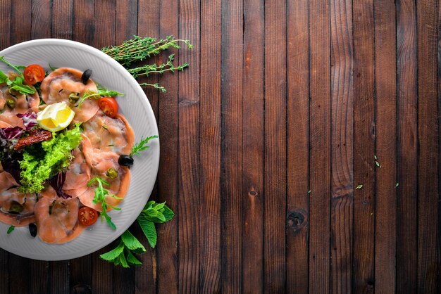 Carpaccio von Fischgemüsekäsegewürzen zum hölzernen Hintergrund Draufsicht Freier Platz