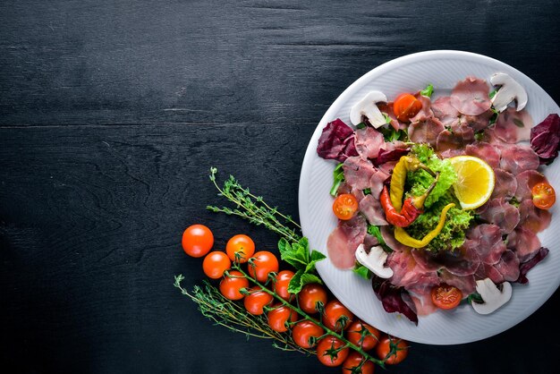 Carpaccio von Rindergemüse-Käse-Gewürzen zu Holzhintergrund Draufsicht Freier Speicherplatz