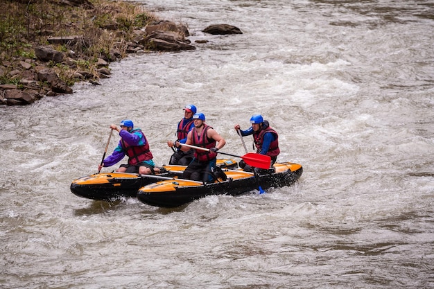 Cárpatos Ucrania 01 de mayo de 2015 Equipo de rafting salpicando las olas rafting deporte extremo y divertido Grupo de personas con guía rafting en aguas bravas y remo en barco de rafting deporte extremo